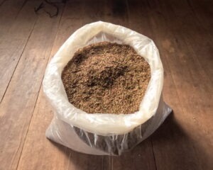 Red crushed kratom leaves in a big plastic bag on the floor