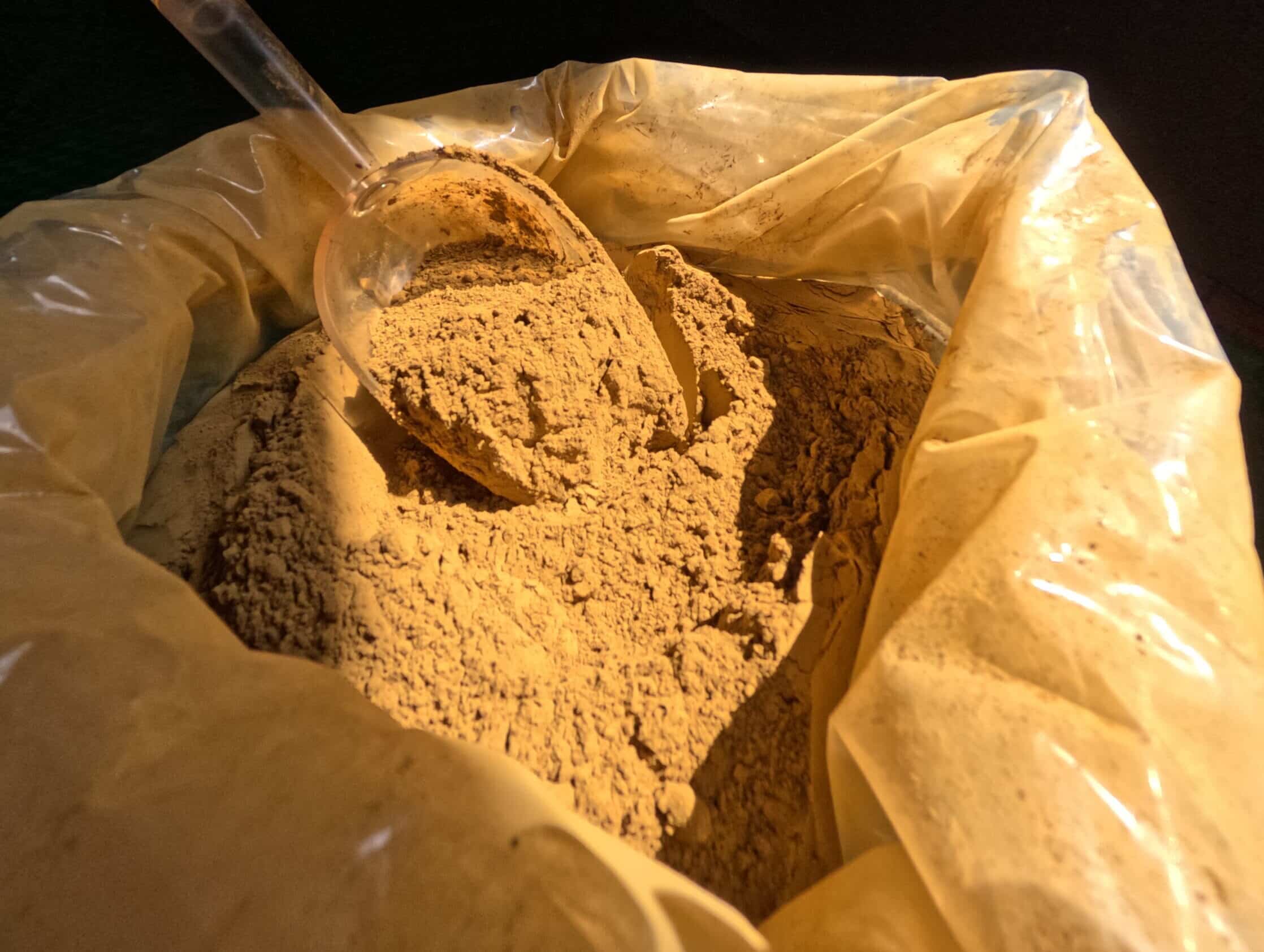 Poudre de kratom rouge dans un sachet en plastique sur fond sombre