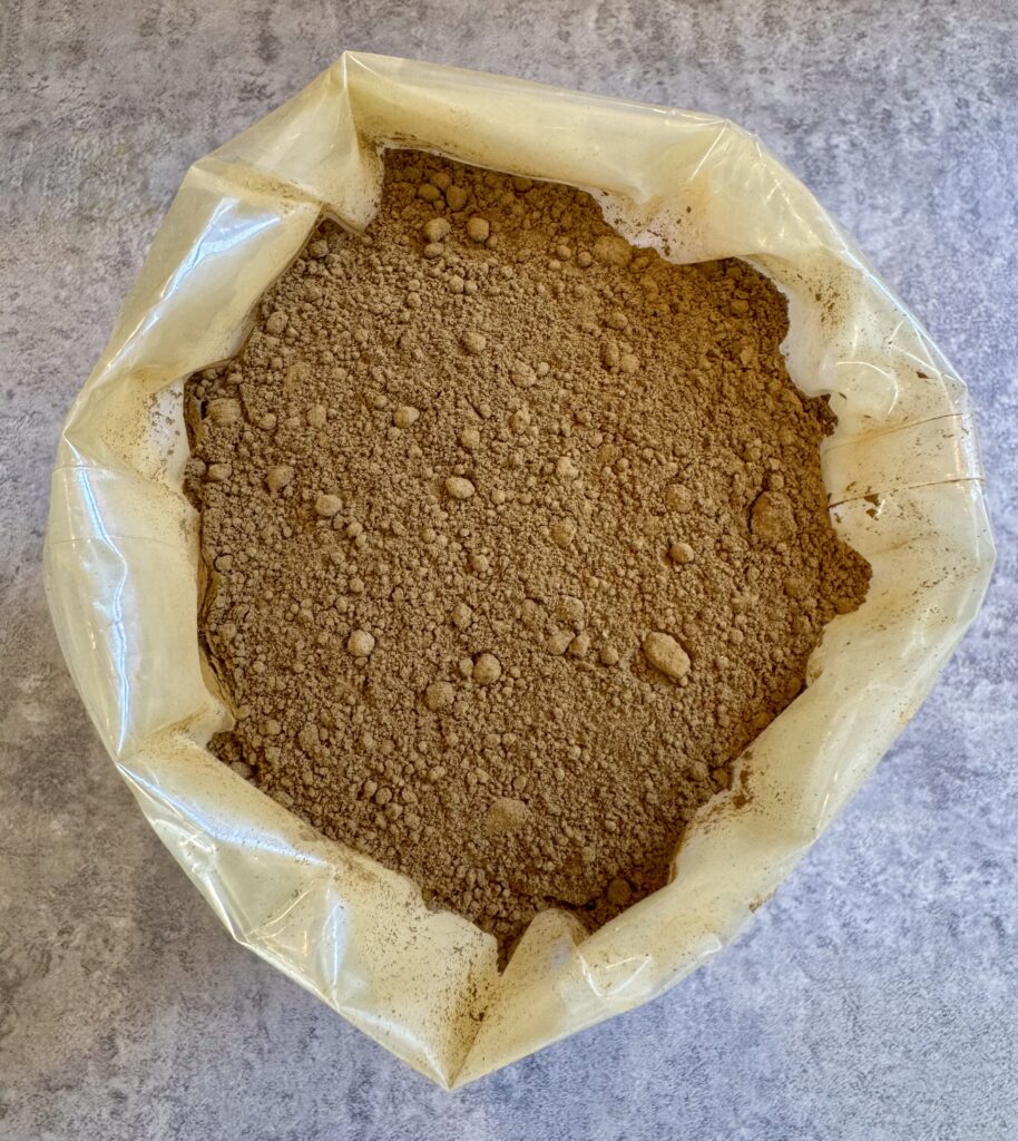 Red kratom powder in a rolled plastic bag