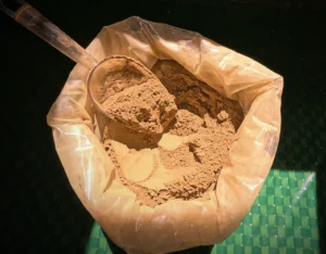Gold Kratom powder in a pouch with a plastic spoon in it