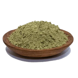 Green powder in a wooden bowl, commonly used as a natural supplement for health benefits, showcasing its fine texture and vibrant color