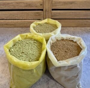 Pack of green, gold and red kratom powder in bags, front view