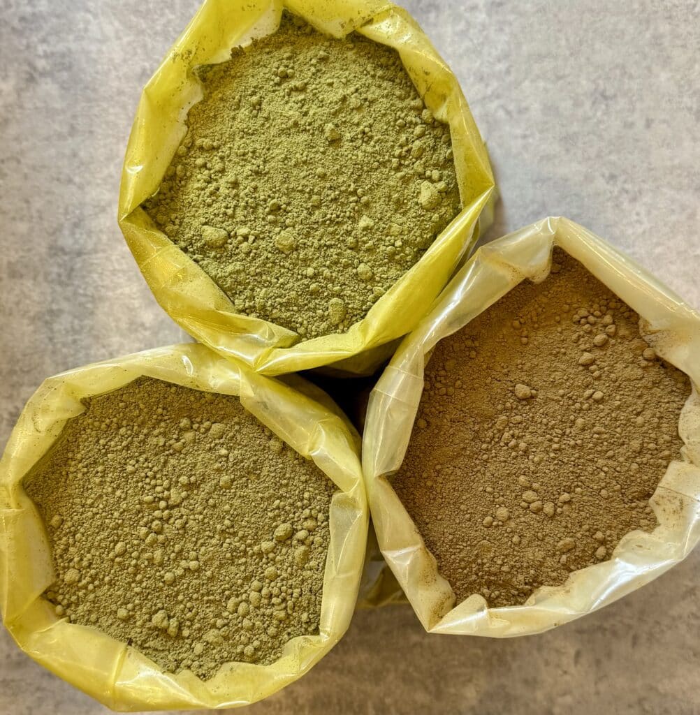 Lot de sachets de poudre de kratom verte, dorée et rouge, vue du dessus