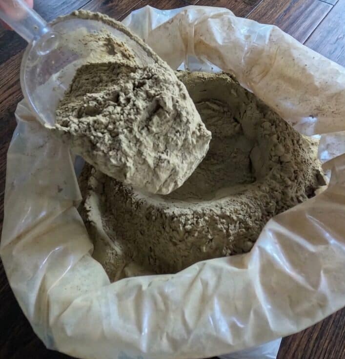 White kratom powder in a pouch with a scoop
