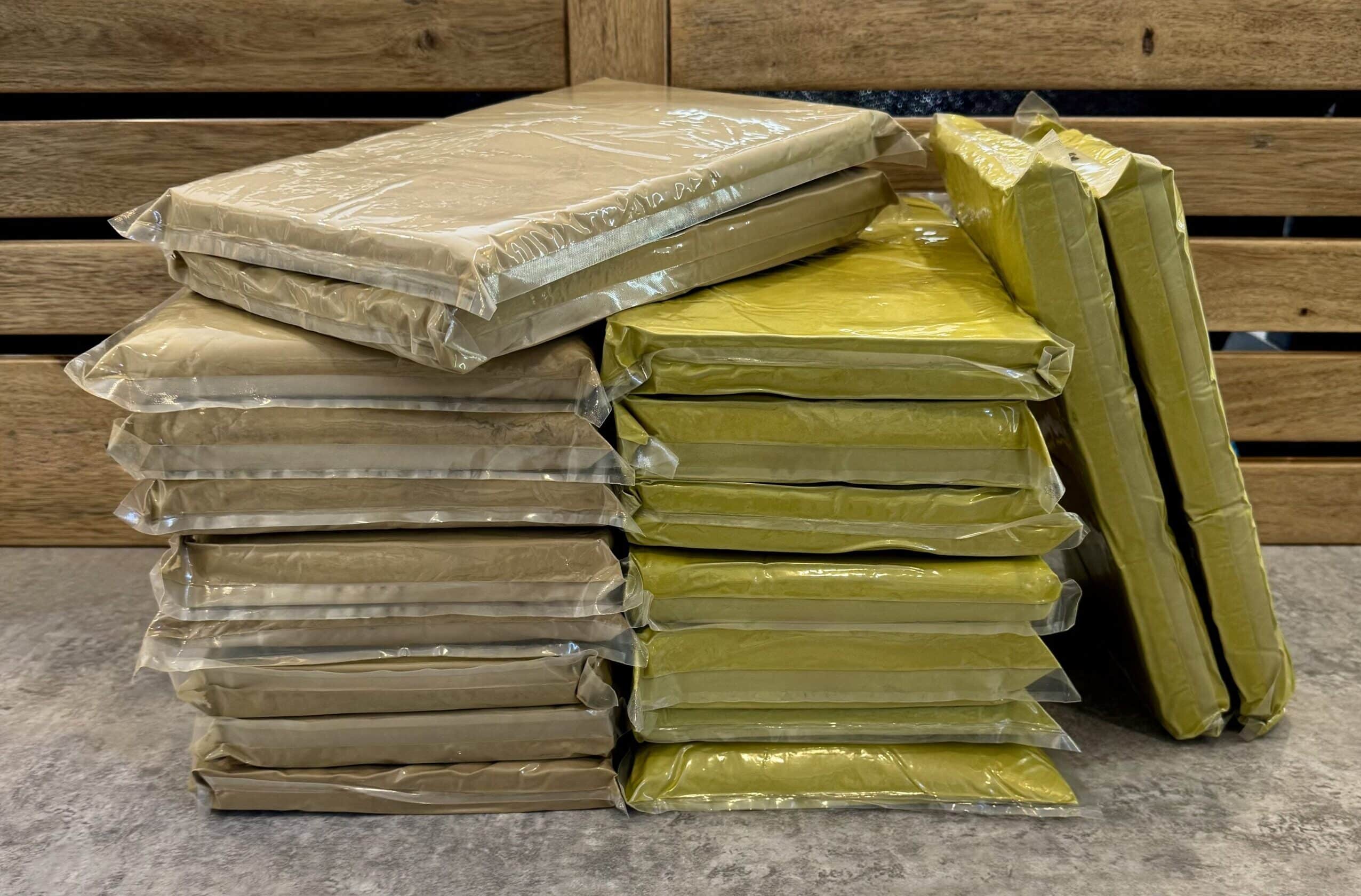 Pile of red and green kratom 1kg packs for bulk selling