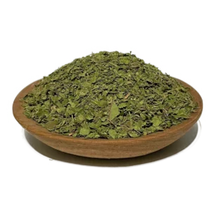 crushed Kratom leaves for tea mounted on a wooden bowl