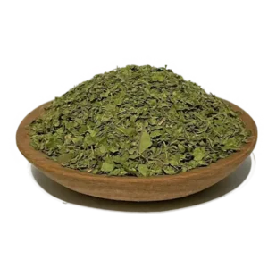 crushed Kratom leaves for tea mounted on a wooden bowl