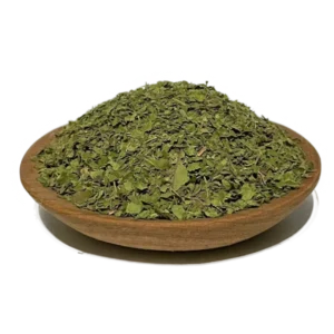 crushed Kratom leaves for tea mounted on a wooden bowl